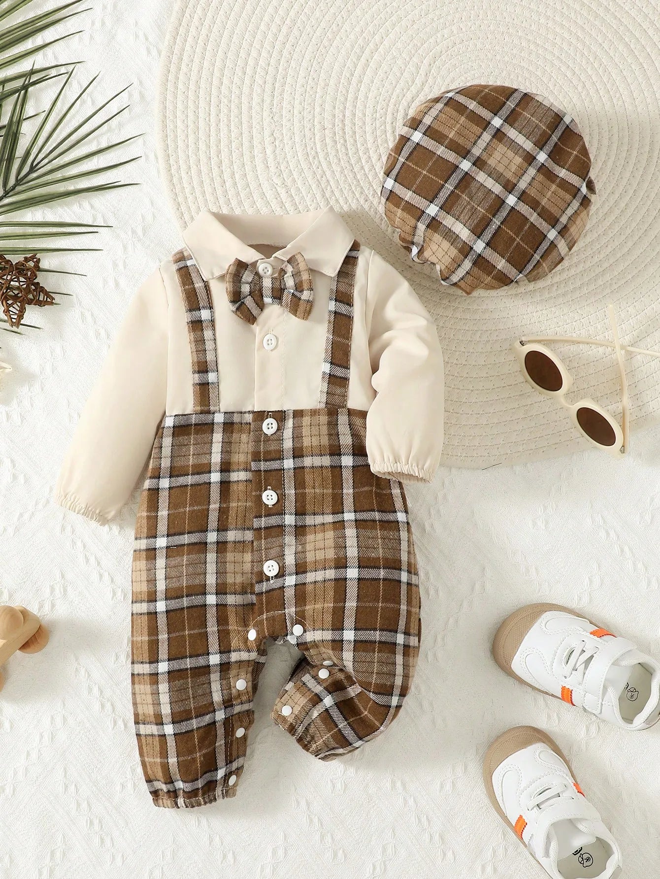 Baby boy dressed in a gentleman suspenders jumpsuit and matching hat from Baby Bubble, stylish and adorable for special occasions.