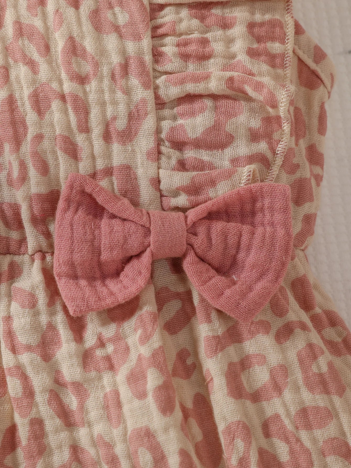 Baby Girl summer pink jumpsuit with bow, paired with a matching headband, by Baby Bubble, perfect for warm weather.