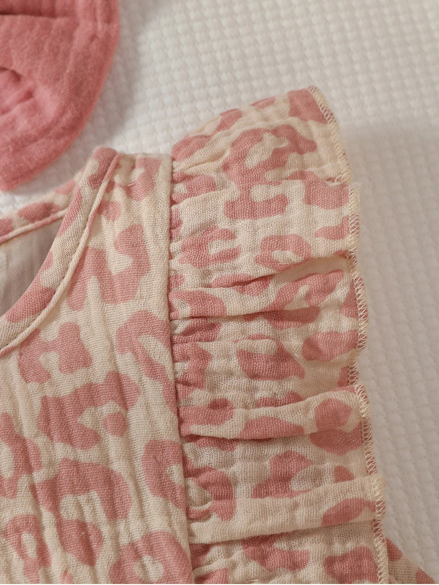 Baby girl wearing a pink summer jumpsuit with a bow, paired with a matching headband from Baby Bubble.